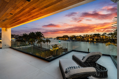 wilight waterfront view from a luxury home in Surfside overlooking the Intracoastal with palm trees and sunset sky